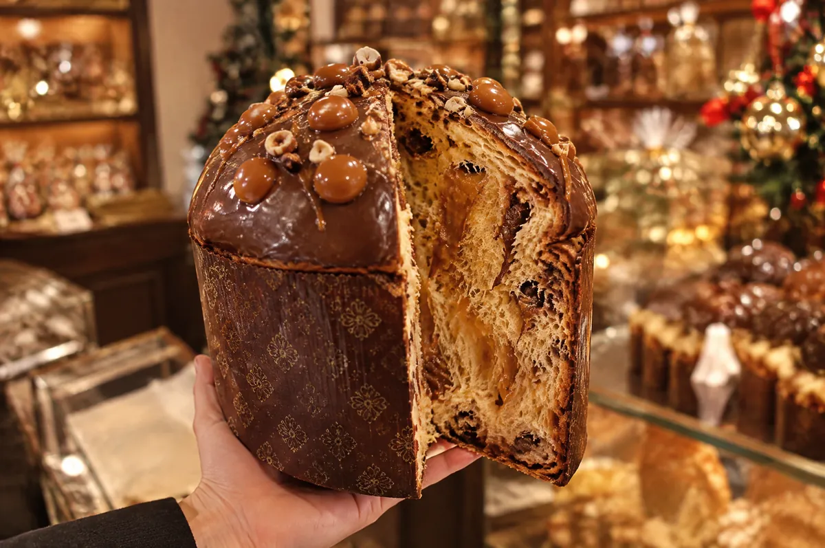Panettone artigianale gianduia e caramello tenuto in mano